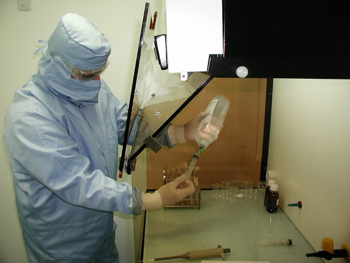 <p>Técnico con la vestimenta adecuada para trabajar en zonas limpias bajo campana de flujo laminar.</p>